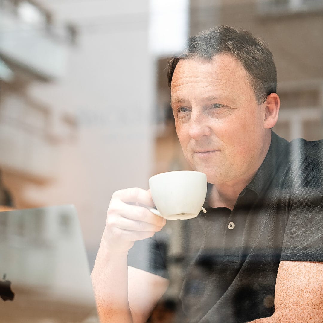 Die Businessfotografie aus St. Gallen zeigt Portrait von ehemaligem Architekt beim Kaffeetrinken