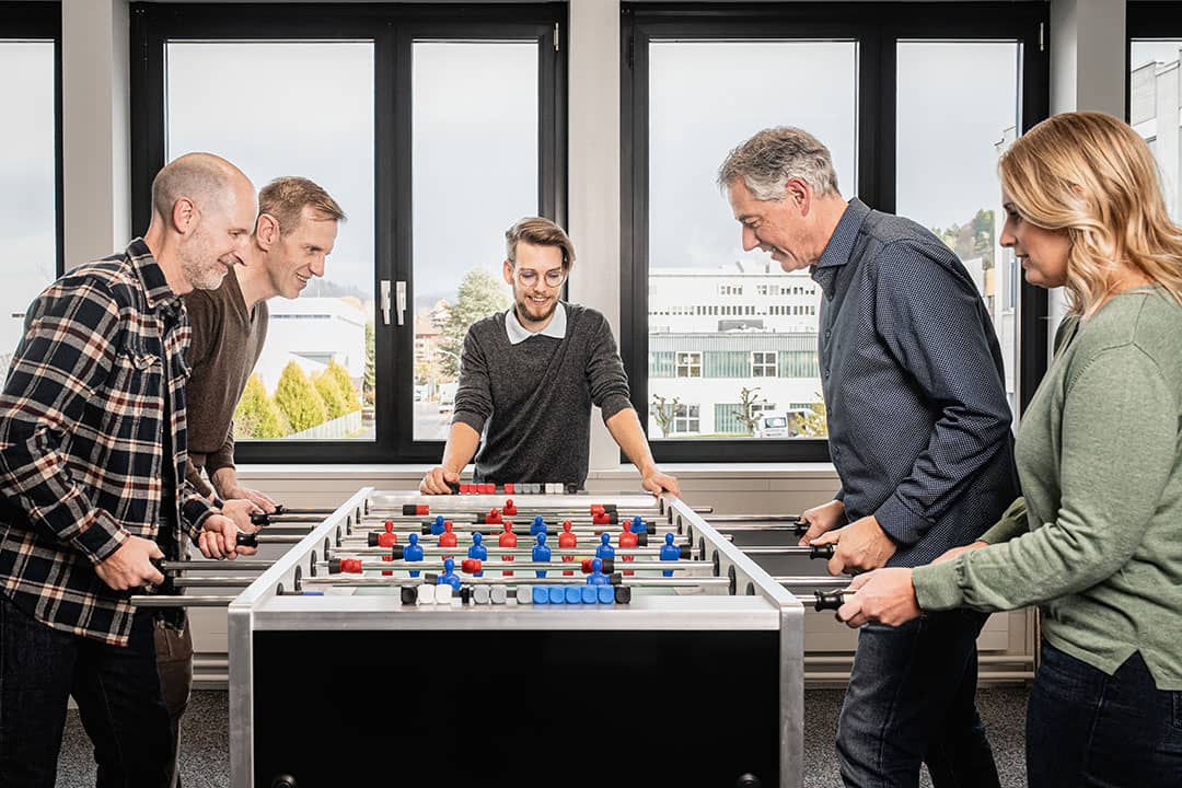 Kreative Mitarbeiterfotos aus St Gallen, Team spielt Tischfussball